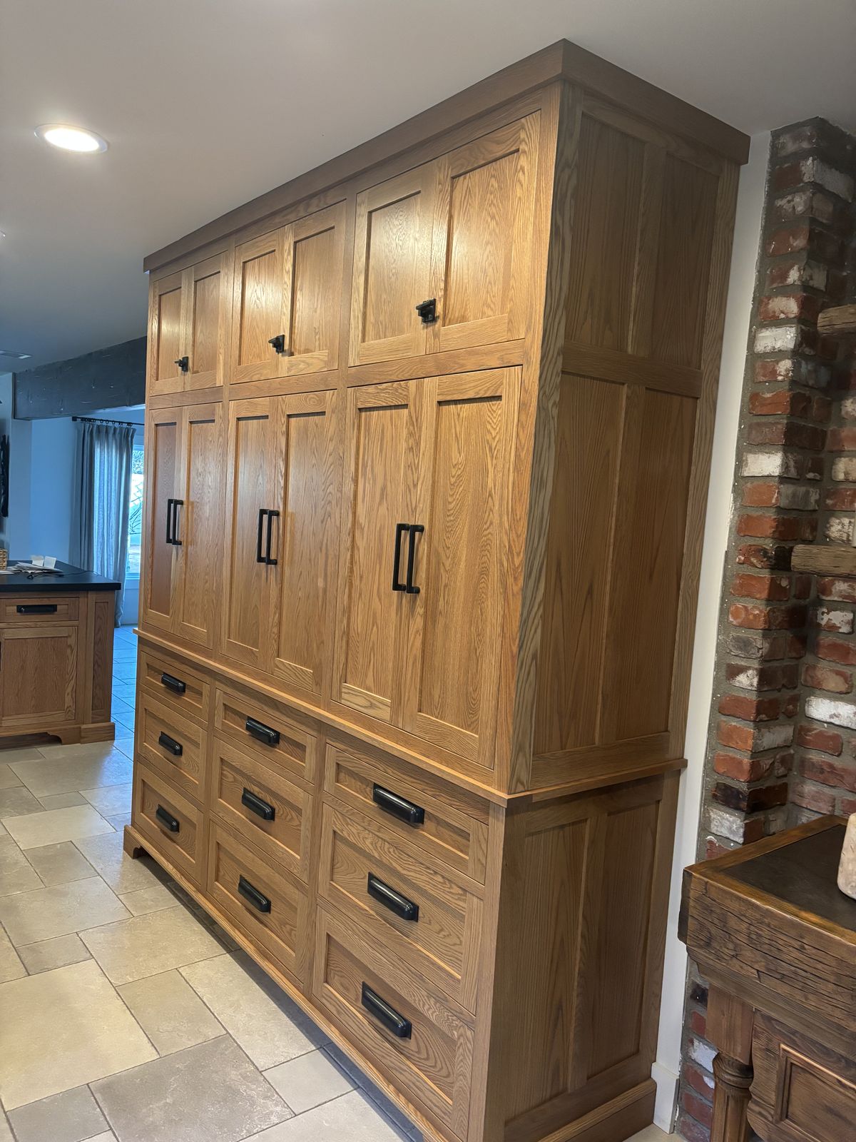 Tall oak built-in storage pantry with black hardware in a Santa Ynez, CA home