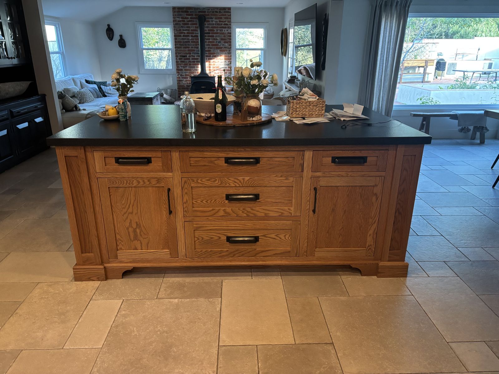 Stained oak kitchen island with a black countertop in Los Olivos, CA