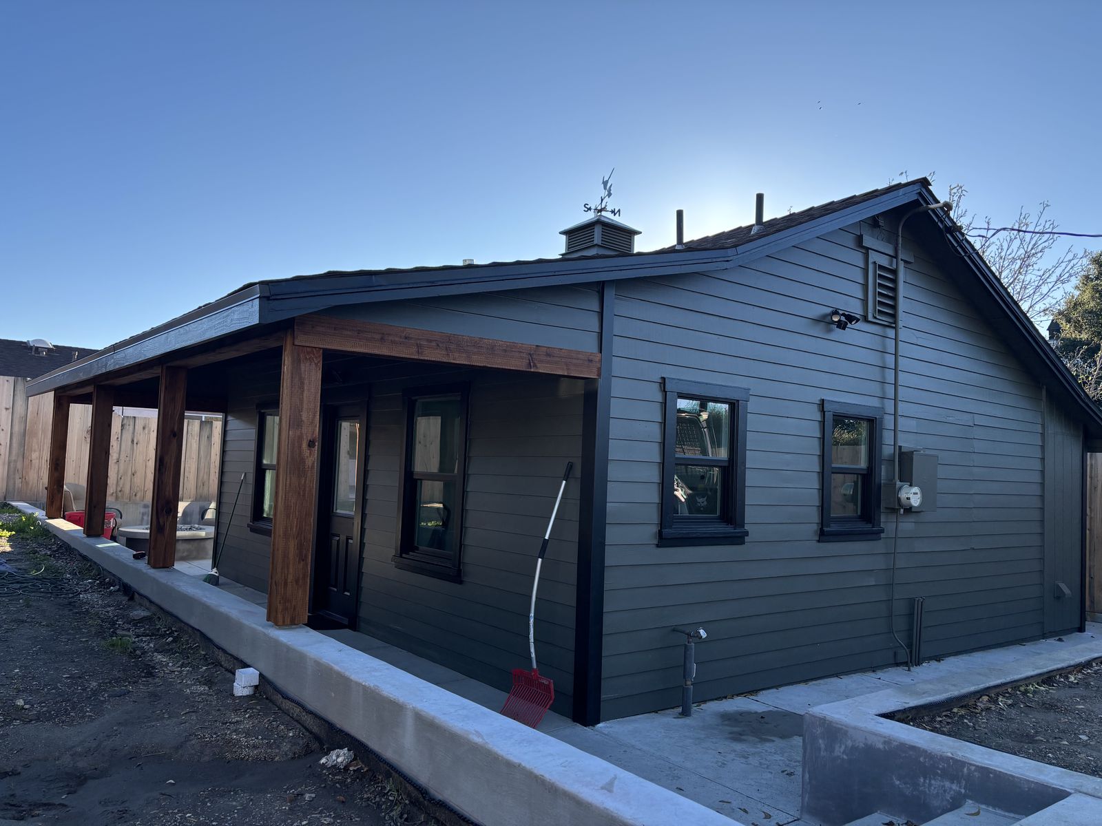 Dark charcoal wood-siding home exterior with stained porch posts in Solvang, CA