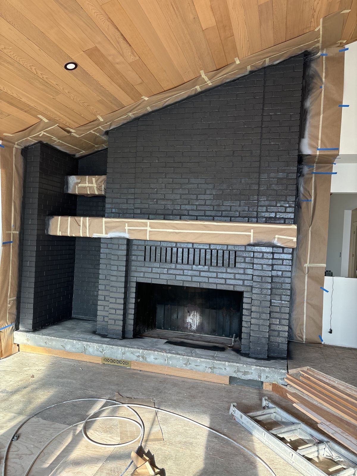 Brick fireplace painted charcoal black, work in progress, in Santa Ynez, CA
